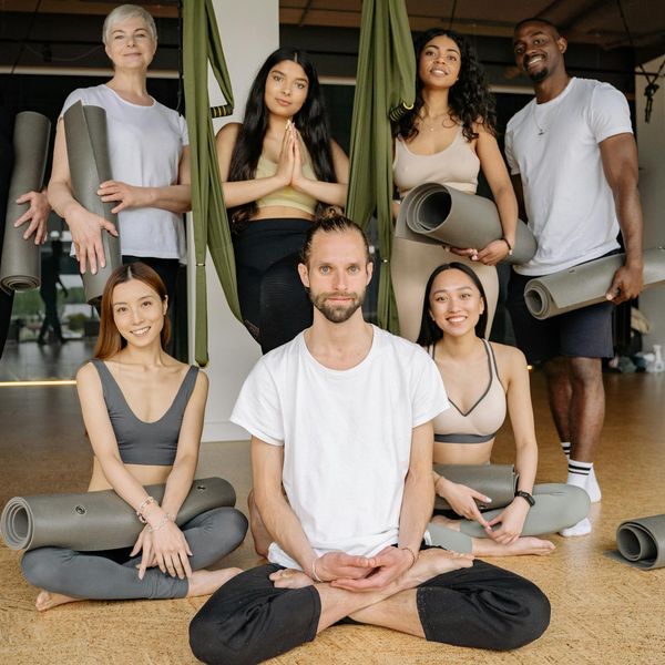 Group of diverse people smiling and relaxed after a yoga class.